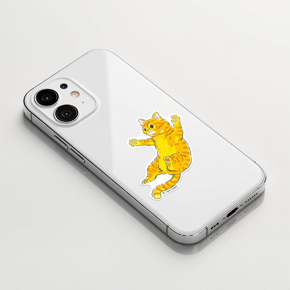 Cute Tabby Cat Jumping ✦ B-Side Label Sticker on a white iPhone