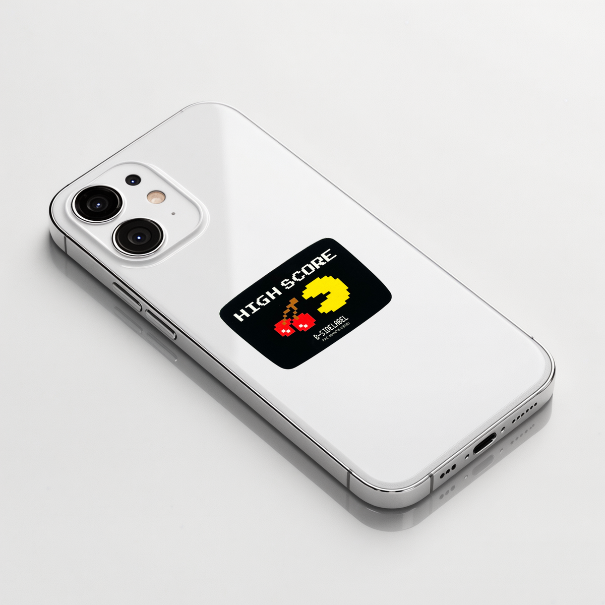 Pac Man High Score ✦ B-Side Label Sticker shown on a white iPhone; illustrative placement, not to scale.
