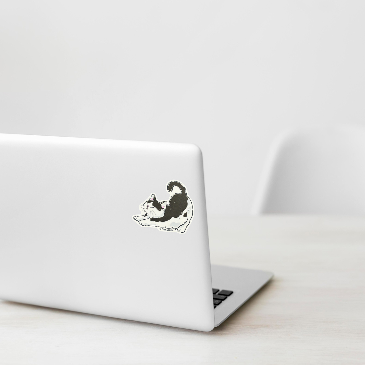 Black & White Cat Stretching ✦ B-Side Label Sticker shown on a white laptop; illustrative placement, not to scale.