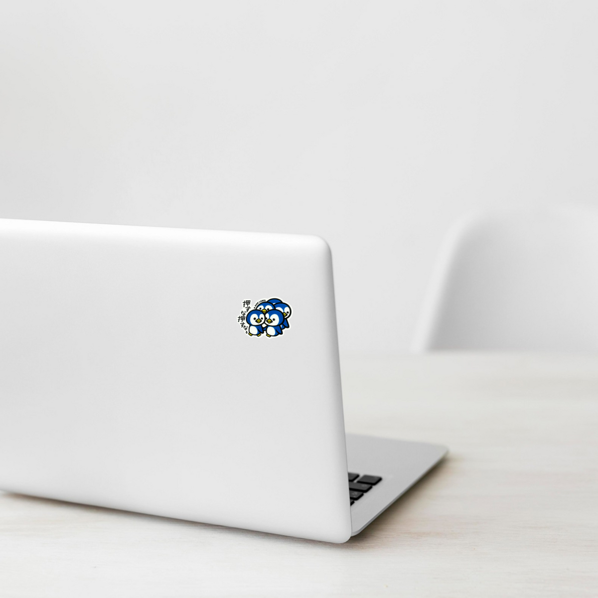 Cute Baby Penguin Group ✦ B-Side Label Sticker on a white laptop — Shopify Small template, original photograph